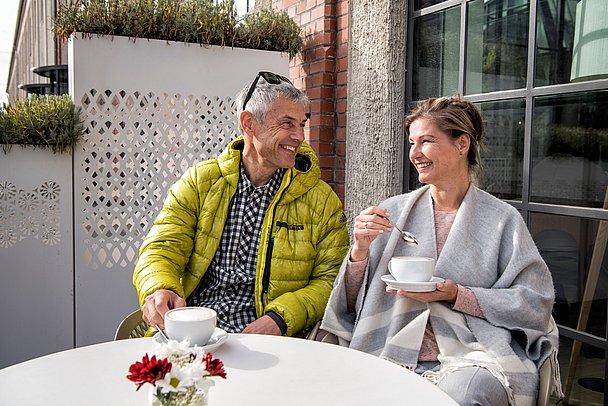 Paar trinkt vor dem Textilmuseum Kaffee im Freien Paar trinkt vor dem Textilmuseum Kaffee im Freien