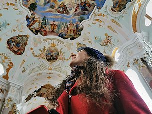 Frau besichtigt barockes Deckengemälde in der Frauenkirche Günzburg