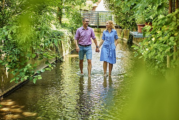 Paar wandert im Wasser beim Kneippbecken im Gerberviertel in Nördlingen