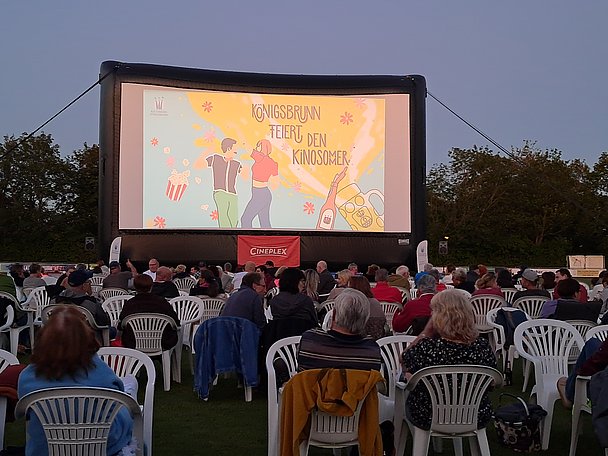 Kinosommer Königsbrunn mit Publikum das auf Leinwand blickt Kinosommer Königsbrunn mit Publikum das auf Leinwand blickt