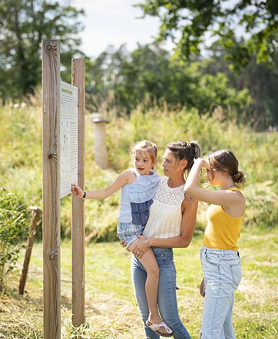 Besucherinnen stehen vor einer Infotafel im Botanischen Obstgarten „Schäbles Kleinod“ bei Wemding. Besucherinnen stehen vor einer Infotafel im Botanischen Obstgarten „Schäbles Kleinod“ bei Wemding.