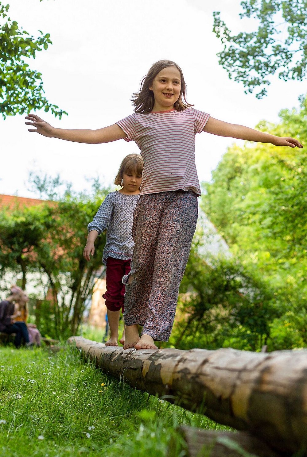 Kinder balancieren auf Baumstamm im Mooseum Bächingen