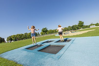 Zwei Kinder hüpfen Trampolin im Wiley-Park Neu-Ulm
