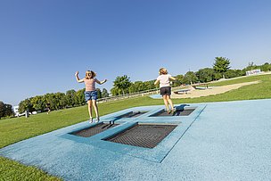 Zwei Kinder hüpfen Trampolin im Wiley-Park Neu-Ulm