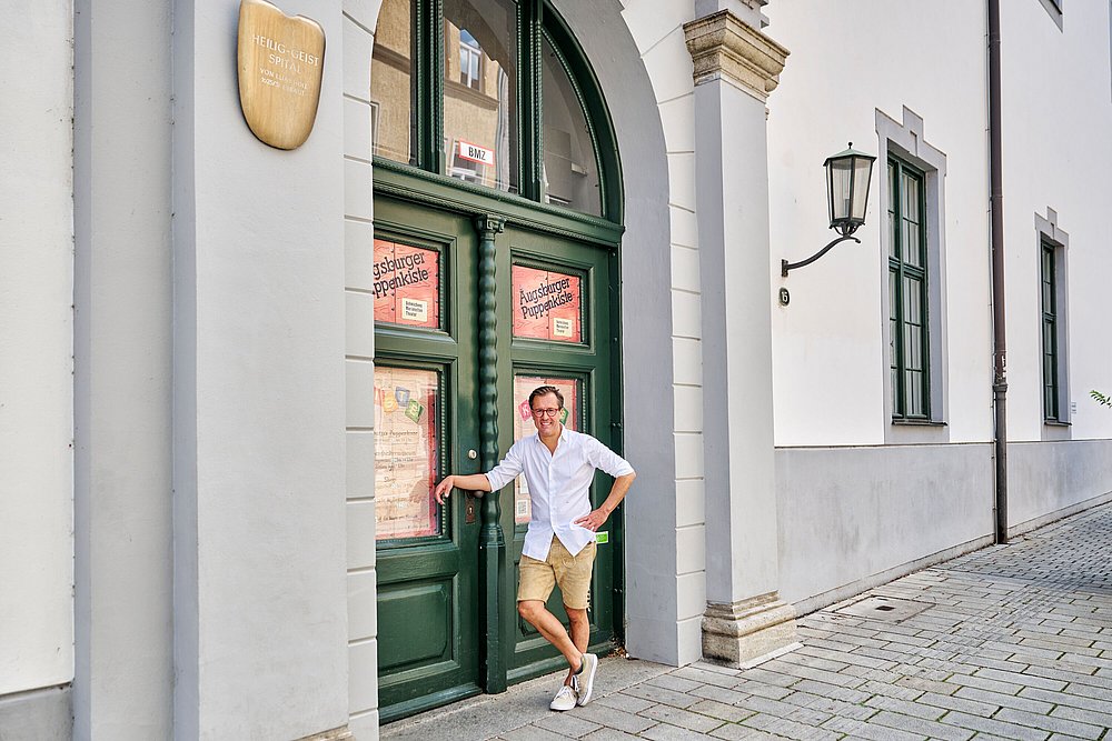 Mann in Lederhose vor Eingang zur Augsburger Puppenkiste Mann in Lederhose vor Eingang zur Augsburger Puppenkiste