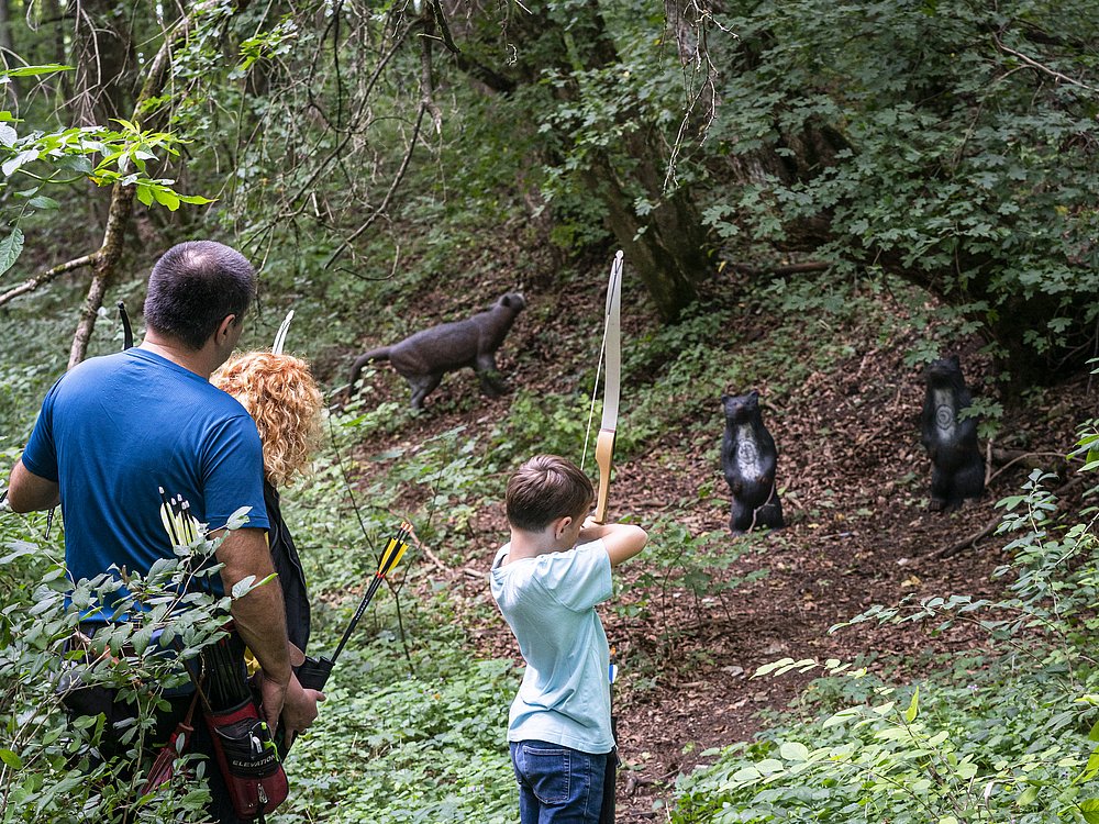 Eine Familie beim Bogenschießen im Wald Eine Familie beim Bogenschießen im Wald