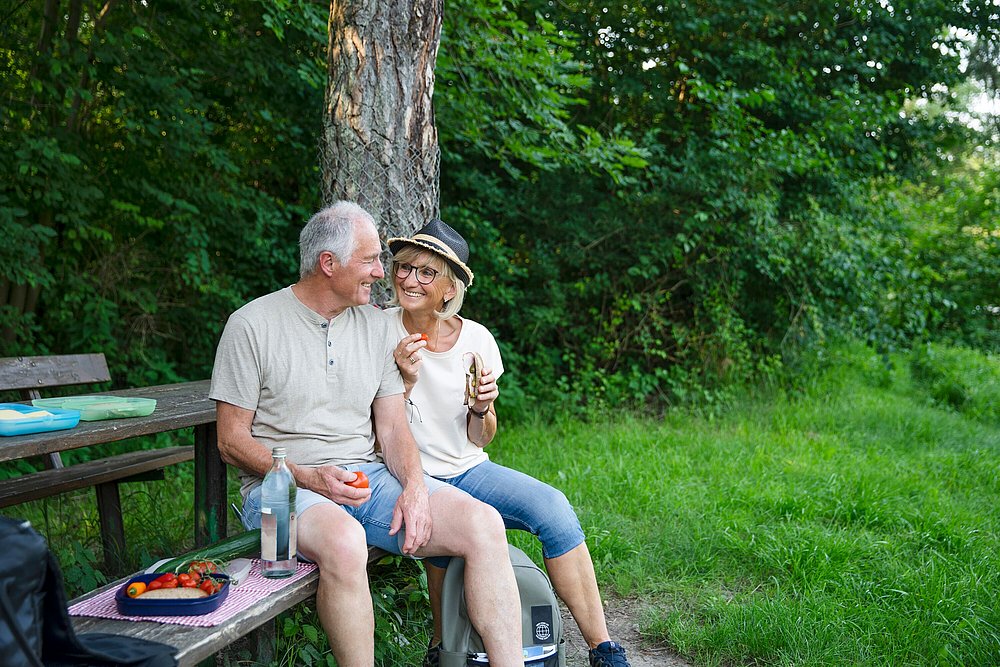 Pärchen auf Parkbank bei einer Wanderpause