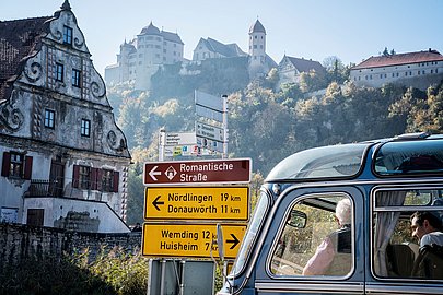 Blick auf die Harburg von der Stadt im Tal mit Fachwerkhaus und Oldtimerbus