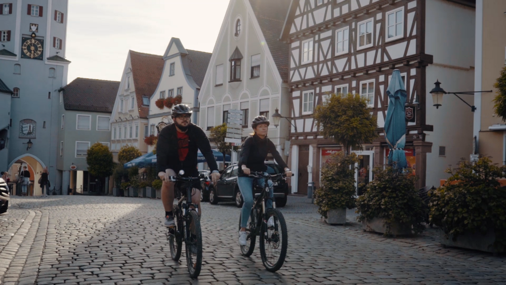 Zwei Fahrradfahrer am Marktplatz Günzburg auf Kopfsteinpflaster Zwei Fahrradfahrer am Marktplatz Günzburg auf Kopfsteinpflaster