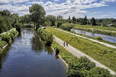 Zwei Radfahrer fahren auf dem Damm an der Wertach 