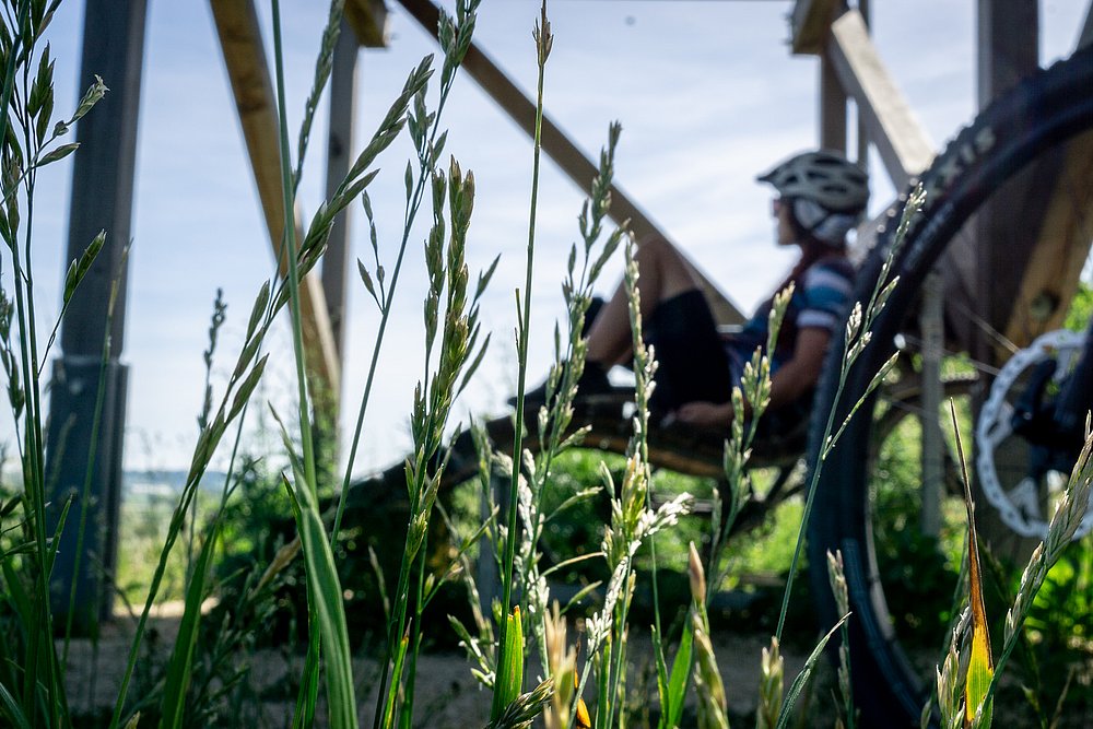 Radfahren am Fluss mit Pause einer Radlerin im Dattenhauser Ried