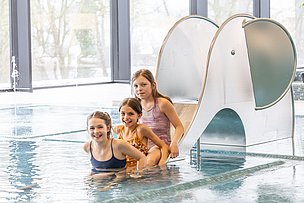 Drei Kinder auf der Rutsche im Kraterbad Drei Kinder auf der Rutsche im Kraterbad