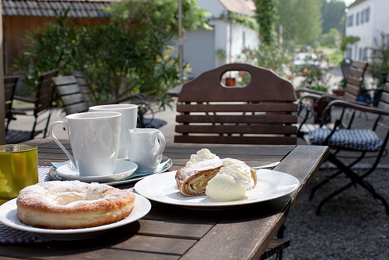 Kaffee und Kuchen mit Sahne in schönem Ambiente eines Straßencafés Kaffee und Kuchen mit Sahne in schönem Ambiente eines Straßencafés