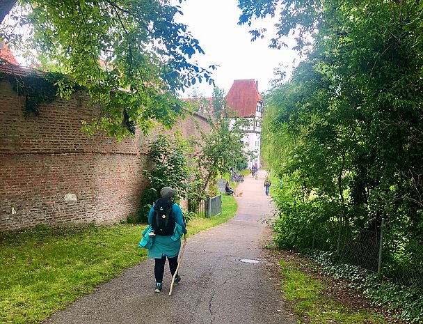 Wandernde Frau an der historischen Stadtmauer in Donauwörth Wandernde Frau an der historischen Stadtmauer in Donauwörth