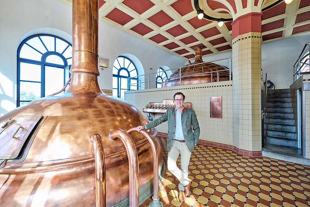 Brauer vor Braukessel in historischem Sudhaus Brauer vor Braukessel in historischem Sudhaus