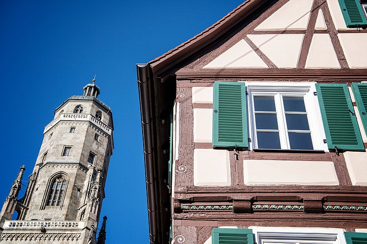 Blick auf den Kirchturm Daniel und ein altes Fachwerkhaus in Nördlingen