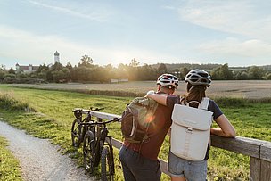 Paar pausiert auf der Fahrradtour vor dem Kloster Wettenhausen Paar pausiert auf der Fahrradtour vor dem Kloster Wettenhausen